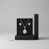 Silver necklace with a large teardrop crystal pendant and matching floral stud earrings in a black gift box.