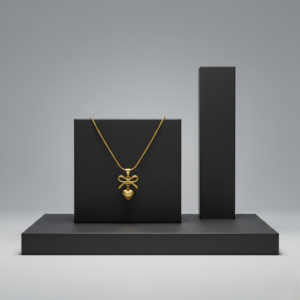 Gold heart necklace with a bow pendant displayed on a black geometric stand.