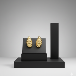A pair of high-polish gold ribbed earrings displayed on a minimalist black jewelry stand against a grey background.