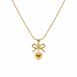 Gold bow and heart pendant necklace on a gold snake chain, isolated on a white background.