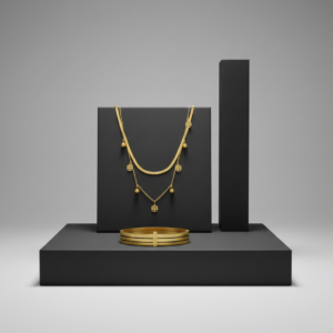 A gold layered necklace with tree of life charms and a matching gold bangle displayed on matte black geometric stands.