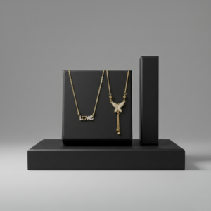 Two gold necklaces, one with a "Love" script pendant and another with a crystal butterfly tassel, displayed on black matte blocks.