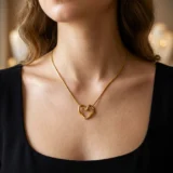 Gold open-heart pendant necklace with a knotted snake chain.