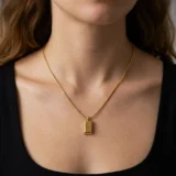 Front view of a minimalist gold bar necklace on a white background.