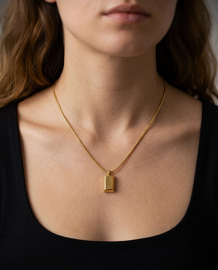 Front view of a minimalist gold bar necklace on a white background.