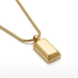 Close-up of a gold bar pendant on a thick snake chain.